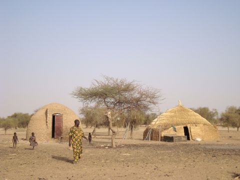 Woodless construction hut next to traditional shelter.
